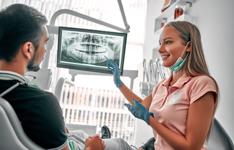 Image of doctor or dentist presenting with tooth x-ray film recommend patient in the treatment of dental and dentistry, working at workplace.