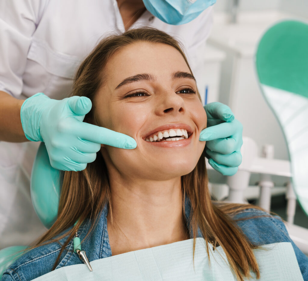 dental assistant showing young lady how to floss