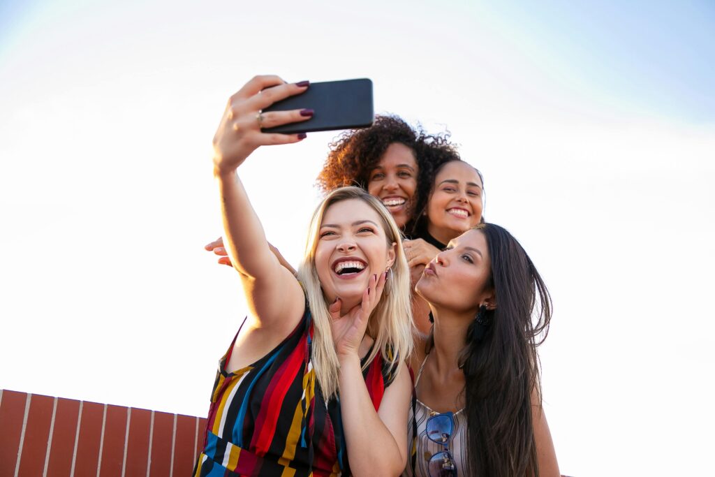 four young ladies talking a selfie with beautiful smiles